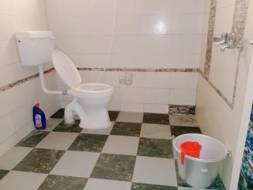 a bathroom with a toilet and a garbage can at Square & Dormitory Stays in Tirunelveli