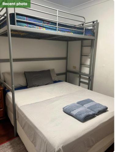 a bedroom with a bunk bed with a blue towel at MJED House Australia in Ingleburn