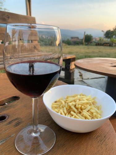 a glass of wine and a bowl of pasta at B&B EcoAntico casa in paglia in Maiolo