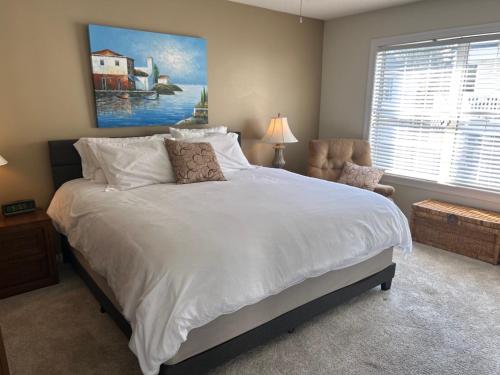 默特尔比奇Its JTs的卧室里有一张白色的大床和一把椅子