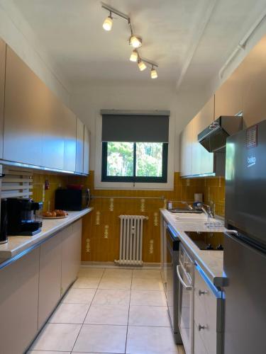une grande cuisine avec des armoires blanches et une fenêtre dans l'établissement Charming apartment in the centre of Cannes, à Cannes