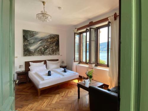 a bedroom with a bed and a couch and windows at Villa Streintz in Millstatt