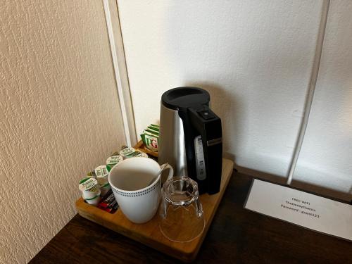 a coffee maker and a cup on a table at The Derby Hotel in Barrow in Furness