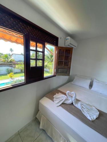 a bedroom with a bed with a towel on it at Pousada Sunshine Patacho - Praia do Patacho - Rota Ecológica dos Milagres, Porto de Pedras in Pôrto de Pedras