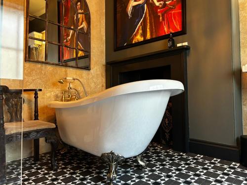 a white bath tub in a bathroom with a fireplace at Golden Fleece York in York