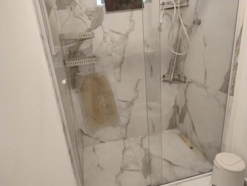 a bathroom with a shower with a marble wall at Sala living 809 in São Vicente