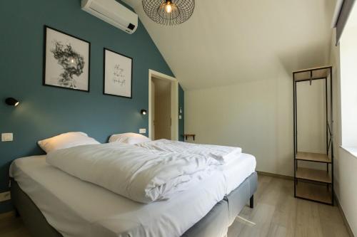 a bedroom with a large bed with white sheets at Vakantiewoning De Ketten in Schoppem
