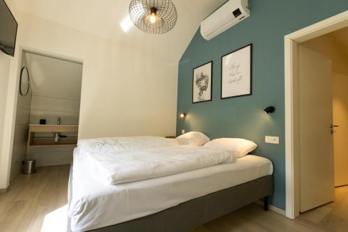 a bed in a room with a blue wall at Vakantiewoning De Ketten in Schoppem