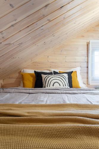 a bed in a room with a wooden wall at Finskä chata in Samopše