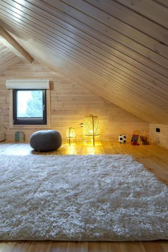 an attic room with a large rug and a window at Finskä chata in Samopše