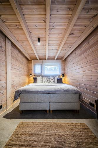 a bedroom with a bed in a wooden wall at Finskä chata in Samopše