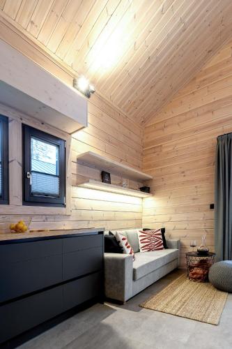 a living room with wooden walls and a couch at Finskä chata in Samopše