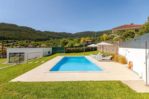 a swimming pool in the yard of a house at Casa do Tourão - Ponte de Lima in Ponte de Lima