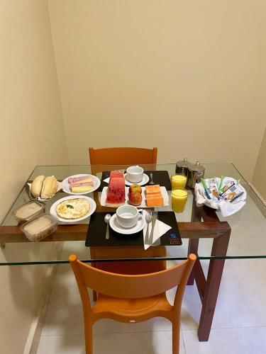 een glazen tafel met borden voedsel erop bij Bora Bora Motel in Salvador