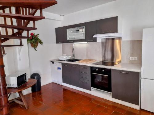 a kitchen with stainless steel appliances and a staircase at La douce étable - 25 minutes d'Agen in Port-Sainte-Marie