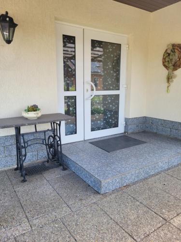 a porch with a table next to a door at Grubschützer Ferienhäuschen in Grubschütz