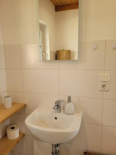a white bathroom with a sink and a mirror at Grubschützer Ferienhäuschen in Grubschütz