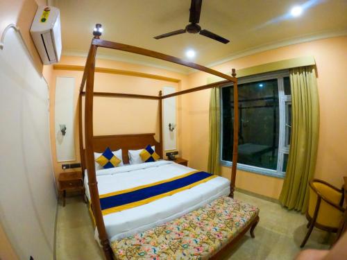 a bedroom with a canopy bed and a window at The Taj Vista Agra -walking distance to Taj Mahal in Agra