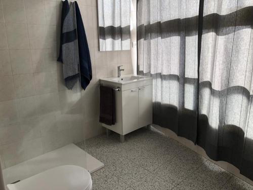 a bathroom with a sink and a shower curtain at Apartamentos NICE CENTRAL BUILDING in El Tablero