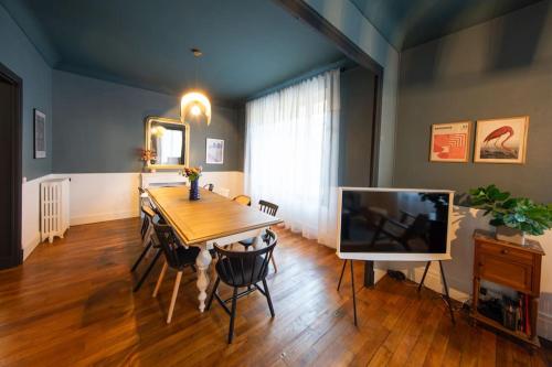 a dining room with a table and a television at Appartement ATHOS - Hyper Centre - Familiale in Orléans