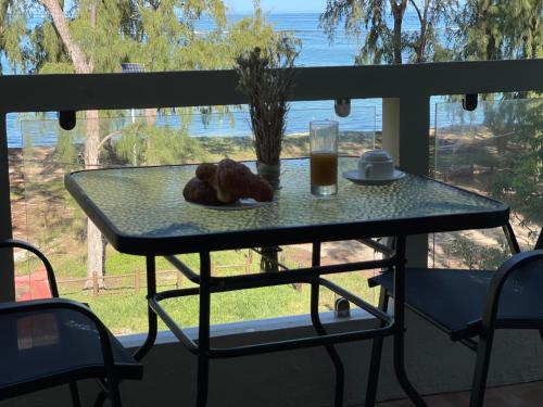 a table with a glass of beer and a teddy bear on it at Phoenix Beach Apartments sea view in Flic-en-Flac