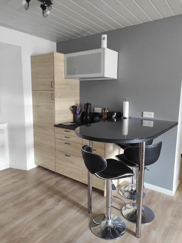 une cuisine avec une table noire et des chaises noires dans l'établissement Appartement à la campagne, à Venteuges