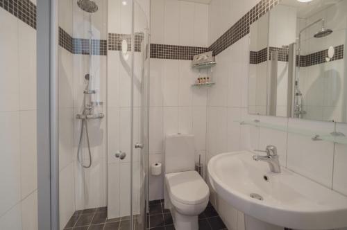 a white bathroom with a toilet and a sink at TwentySix in Malmö