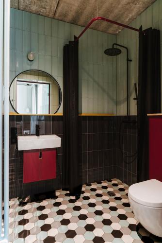 a bathroom with a sink and a toilet and a mirror at Willa Wincent in Gdynia