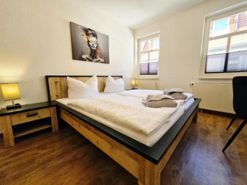 a bedroom with a large bed with white sheets at DM Hotels & Apartments - Apartment Brückenstr 27 in Mühlhausen