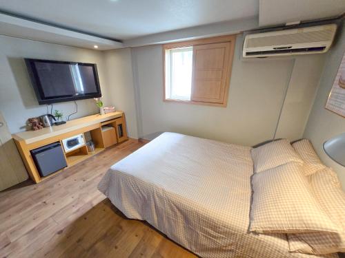 a bedroom with a bed and a flat screen tv at TOP Stay Guro digital complex in Seoul