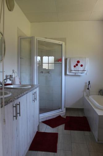 un bagno con doccia, lavandino e vasca di Orkney Resort Guest House a Orkney