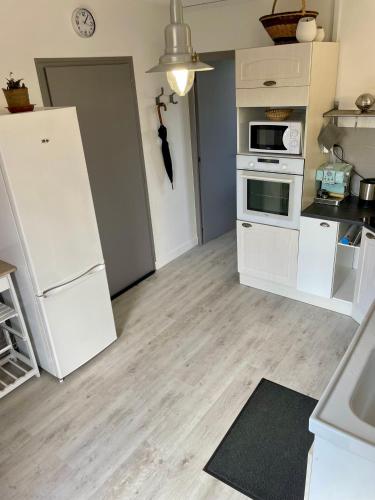 a kitchen with white appliances and a white refrigerator at Gîte en bord de lac in Monsireigne