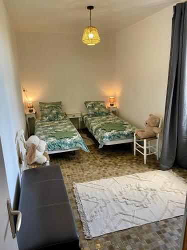 a living room with two beds and a couch at Gîte en bord de lac in Monsireigne