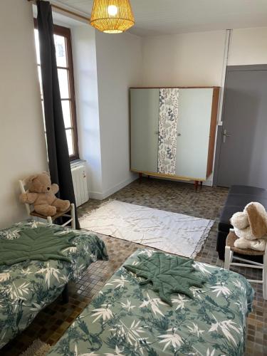 a room with two beds and a table and a window at Gîte en bord de lac in Monsireigne