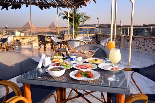 a table with plates of food on a balcony at Topview Pyramids And Museum in Cairo