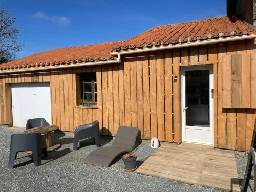 a wooden building with a table and chairs in front of it at Gîte en bord de lac in Monsireigne