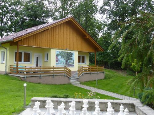 a small yellow house with a fence in front of it at Ferienhaus Zum Kammergut LINKS oder RECHTS in Langenwolschendorf