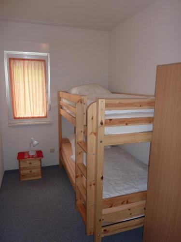 a bedroom with two bunk beds and a window at Ferienhaus Zum Kammergut LINKS oder RECHTS in Langenwolschendorf