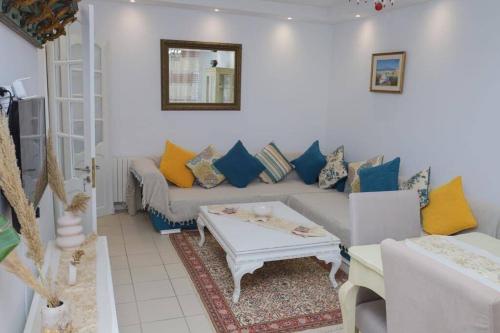 a living room with a couch and a table at Maison bleue in Dar Salah Bey
