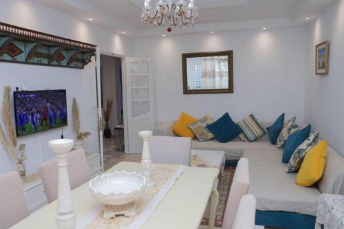 a living room with a couch and a table at Maison bleue in Dar Salah Bey