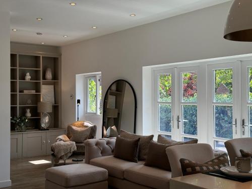 a living room with a couch and chairs and a mirror at Wellsprings Farm - Self-catering studio with private garden in Sacriston