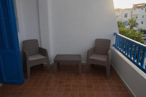 two chairs and a table on a balcony at Maison bleue in Dar Salah Bey