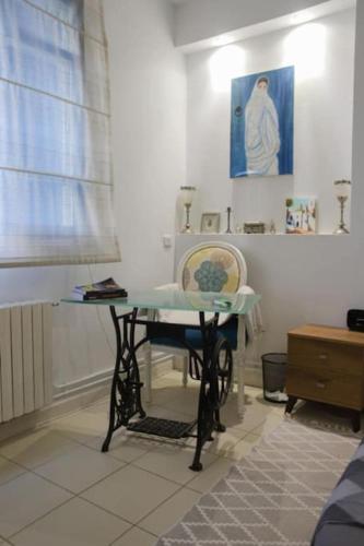 a table in a room with a picture on the wall at Maison bleue in Dar Salah Bey