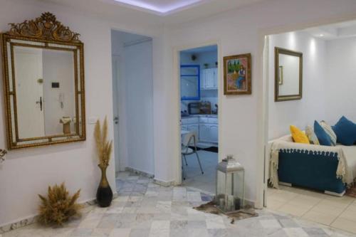 a living room with a mirror and a bed at Maison bleue in Dar Salah Bey