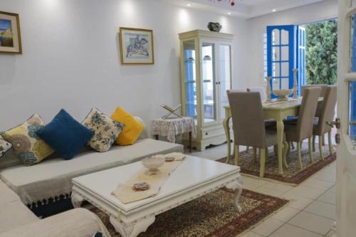 a living room with a couch and a table at Maison bleue in Dar Salah Bey