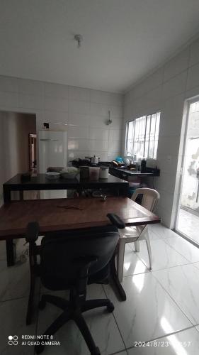 a kitchen with a table and chairs in a room at Casa cachoeira dos tourinhos in Massaguassu