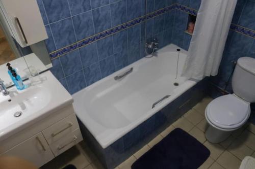 a bathroom with a tub and a toilet and a sink at Maison bleue in Dar Salah Bey