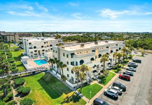an aerial view of a large white building with a parking lot at Royal Mansions, Ocean View Penthouse Condo in Cape Canaveral