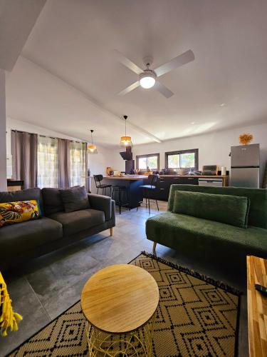 un salon avec deux canapés et une table dans l'établissement Le Cosy entre Terre & Mer, proche Grand'Anse, à Petite Île