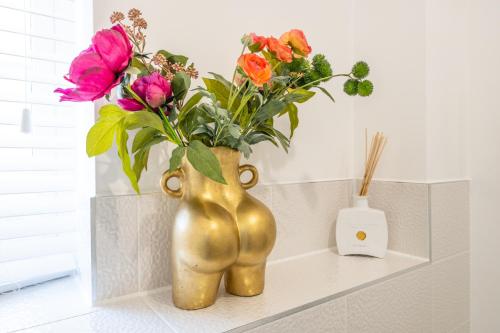 two gold vases with flowers on a shelf at Premium Living Space in Rugby in Rugby